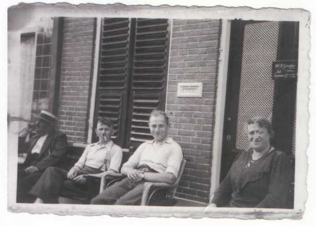Jacob Vecht (links) zit hier naast Hannes Schenk, zijn zoon Moos en zijn vrouw Sophia Vecht-Levie op de stoep voor zijn huis aan de Beekstraat 38. 
