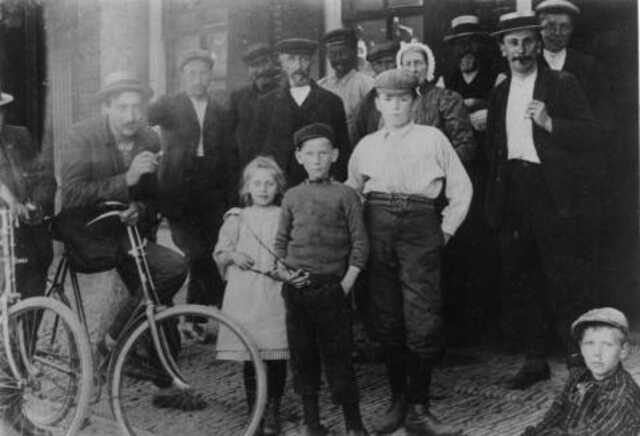 Dorpsbewoners poseren voor de bakkerij van Palsma aan het Boveneind in Leek, 1910