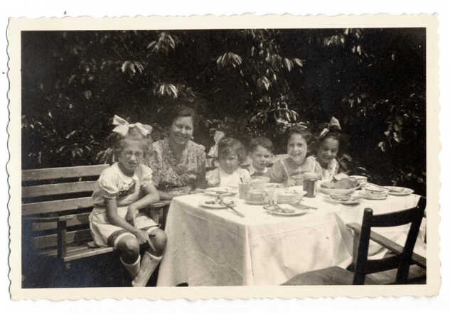 Betty van Aalst (right) and Simon van Aalst (middle) at a table, in hiding amongst other children, also in hiding,  july 4th, 1943 On the far left Els van Hasselt, 2nd on the right Karla Hinderika van Hasselt.