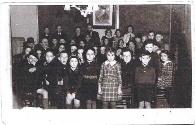 Joodse lagere school in de Voorstraat 41 te Zwolle. Lena Helga staat ook hier half verscholen met het hoofd ietwat gebogen achter Mientje Davidson (geruite jurk) en Joël Simon Frank (met bril). Bron: jwww.joodszwolle.nl, Riek Levie