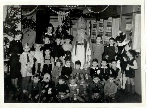 Herman Rudolf Odewald (right next to Sinterklaas) during a  Sinterklaas party at the home of the Odewalds. Somewhere at the bottom row the donor of the picture, Edith Halverstad.