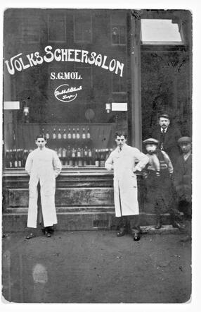 Samuel Mol (rechts) voor zijn kapsalon op het Hang te Rotterdam